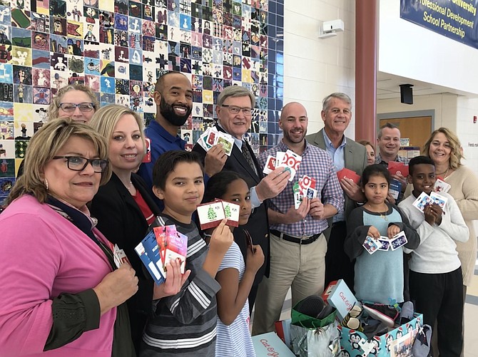 From left, Maria Michlik, parent liaison; Asman Khanal, 10; Aseel Hamza, 9; Lesley Avila Lopez, 9; Abem Teshale, 9; Jenny Phipps, legislative aide for Supervisor Foust; Katie Aldridge and Steven Wilson, Assistant Principals, Hutchison E. S.; Supervisor John W. Foust (D-Dranesville); Ray Lonnett, Principal of Hutchison E. S.; Mike O'Reilly, Chairman of the Board Arts Herndon; Anna Schoenfeld, Director Exhibits, Arts Herndon; Jason DiMambro, Director Outreach Arts Herndon; and  Renee Gorman, School Counselor Hutchison E.S.; display donations from Supervisor John W. Foust's annual holiday shoe drive to benefit students in need at Hutchison E.S. in Herndon.