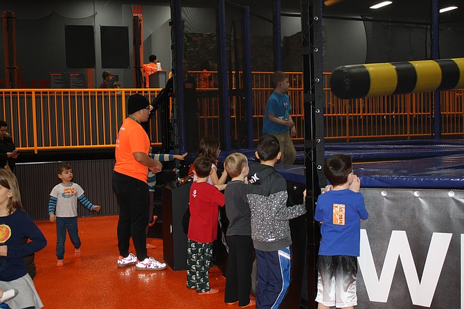 Children watched as others jumped and ducked from the rotating bar.