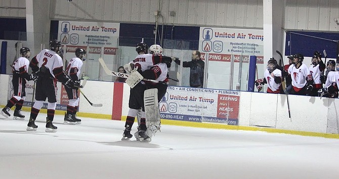 Madison Warhawks forward Matt Hetherington and goalie Ben D’Haiti along with teammates celebrate after the game-winning goal scored by Hetherington against the previously undefeated Chantilly Chargers. The Warhawks would score the game-winning goal with 3 seconds left in a come-from-behind game.