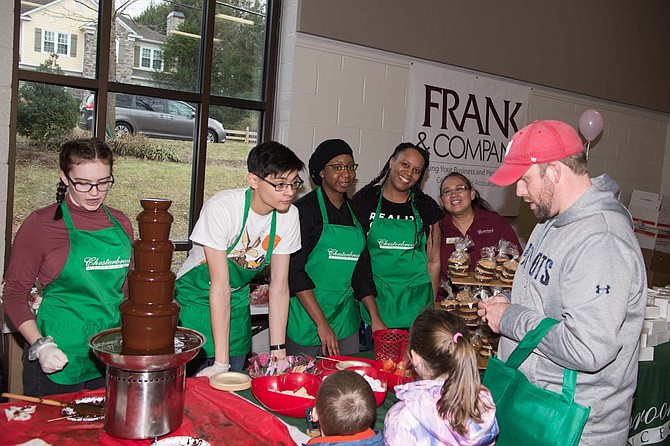 Staff of Chesterbrook Community displaying chocolate products for sale.