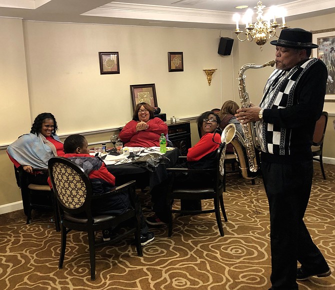 Lolita Robinson and her family are photographed with saxophonist Keith Kool-K Wilson entertaining the group.