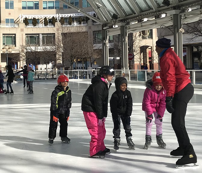 During one of the Learn to Skate Beginner Lessons held Saturday morning, Feb. 2 at the Reston Town Center Ice Skating Pavilion, students practice bending their knees a bit and placing their hands on them while keeping heads up and eyes forward to maintain their center of gravity, gaining control and balance.