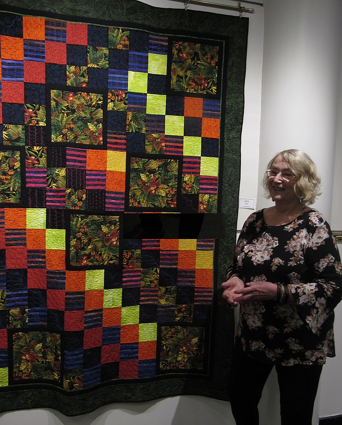 Gloria Morrow, Arts Education Assistant, Reston Community Center, discusses one of the quilted fabric works, "Jungleland,” created by Ruth Grubb of the Town of Herndon and featured in the Group Exhibit, "Through the Eye of the Needle II," by the Cotting Quilters. The show runs Feb. 4–March 3, 2019, in the Jo Ann Rose Gallery, RCC Lake Anne, Reston.