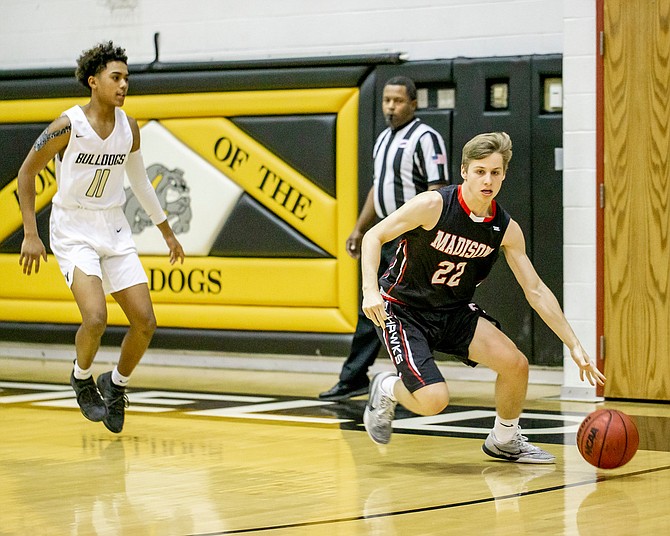 Madison’s TJ Ulrich #22 dribbles the ball up the court trying to avoid the full court pressure of Westfield.