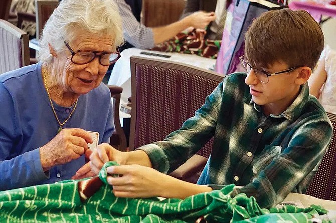 Vinson Hall resident Valerie Vesser and Potomac School ninth grader Ethan Norton enjoy chatting as they work together to create a knot-edged blanket.