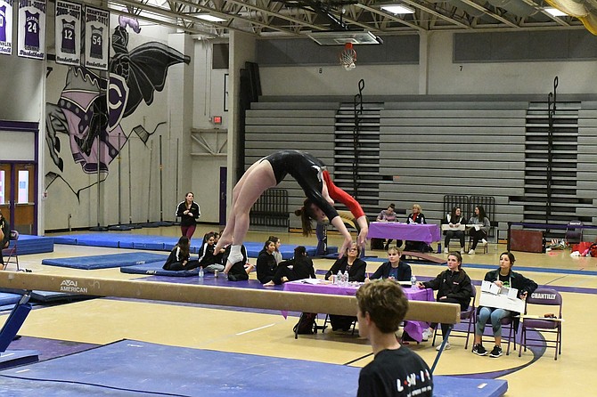 Eliza Loftus, 11th grader at James Madison HS, on the beam. Leading Madison High  to district championships were fourth, sixth, and eleventh-place all arounders, Loftus (36.20), Chloe Breedlove, Grade 10 (34.60), and Christie Noble, a 12th grader (32.775).