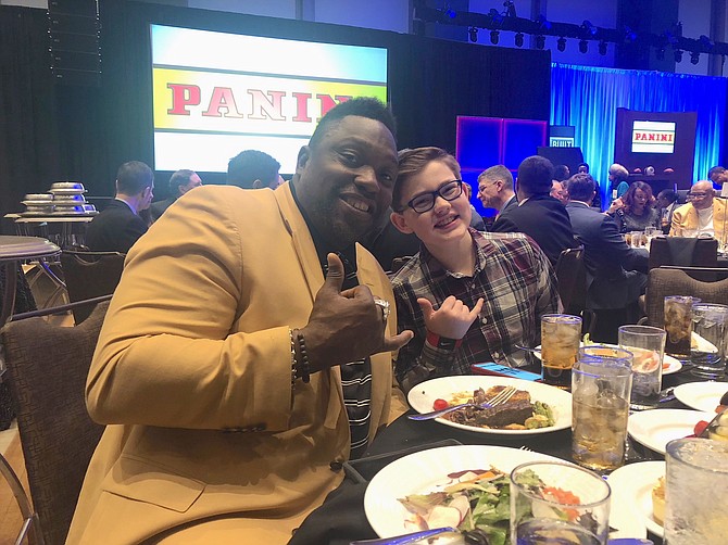 Panini America Super Bowl Kid Reporter Corbin Boehm enjoying a fun moment with one of his favorite players, former Tampa Bay Buccaneer and NFL Hall of Famer, Warren Sapp.