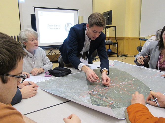 Jack McDowell of Foursquare ITP marks a proposed bus route with a tape line.