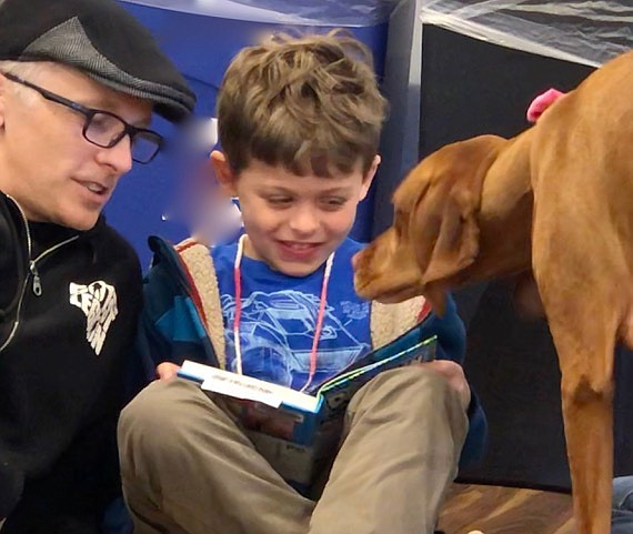 Penny gives Ricky Church a kiss for good reading, with Chris Church.