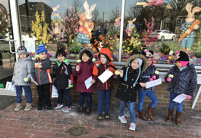 Children from HCC Preschool hold carnations given to them by staff at Herndon Florist after the employees explained their service roles as community helpers in the Town of Herndon.