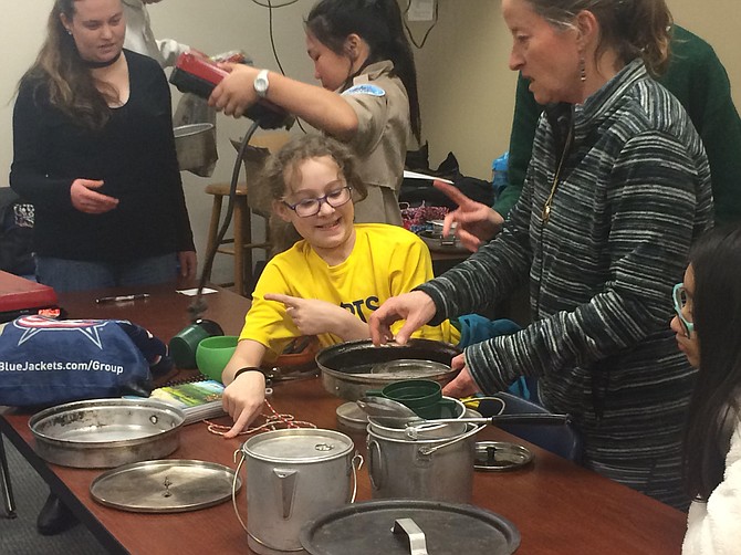 Assistant Scoutmaster Karen Downs helps Scouts sort through the troop's cooking supplies.