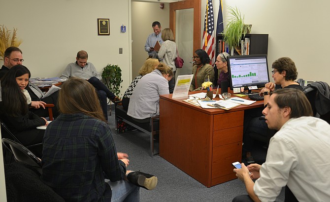 Just waiting. Democratic candidates for 2019 local elections crowd the reception area — and the staff kitchen, and the hallway — of the Fairfax County Democratic Committee headquarters in Fairfax, waiting for the clock to strike noon, the moment when they can officially present their “Declaration of Candidacy” packets.