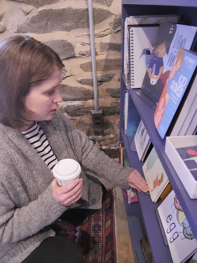 Ally Kirkpatrick looks through her selection of children’s books at Old Town Books. She likes to give children something they haven’t see before — in addition to the classics.