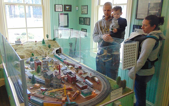 Greg and Christina Kranz of Springfield with their children Quincy and Monty admire the train set.