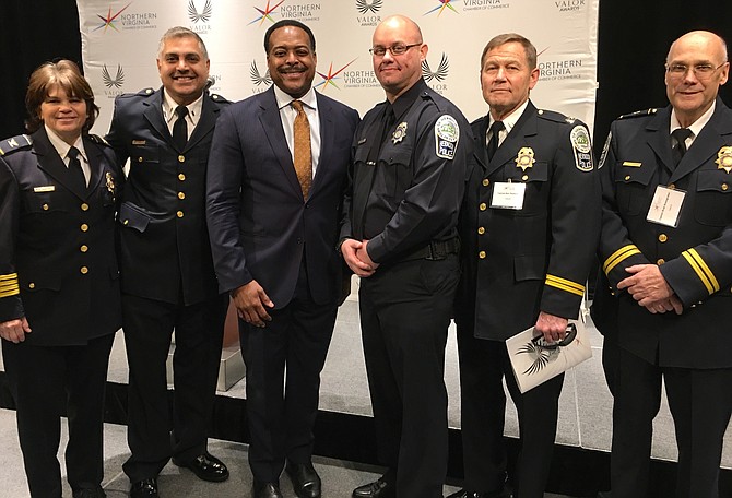 Emcee of the 41st Annual Valor Awards, Leon Harris, News Anchor at NBC4 (third from left), stands with members of the Herndon Police Department: Colonel Maggie A. DeBoard, Chief of Police; Lieutenant Si Ahmad; Police Officer First Class Chris Parker; Captain Ron Thunman; and Captain Brad Anzengruber after Ahmad and Parker are awarded Lifesaving Certificates.
