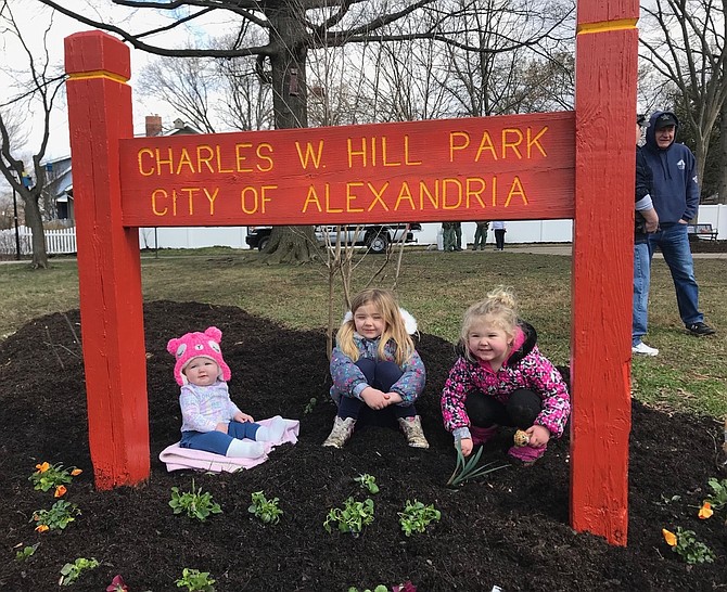 Eleanor, Laila and Audrey Hill sit among the newly planted flowers at the Charles W. Hill Park in Del Ray. The park is named for their late grandfather, Corporal Charles Hill, the last Alexandria police officer to be killed in the line of duty.