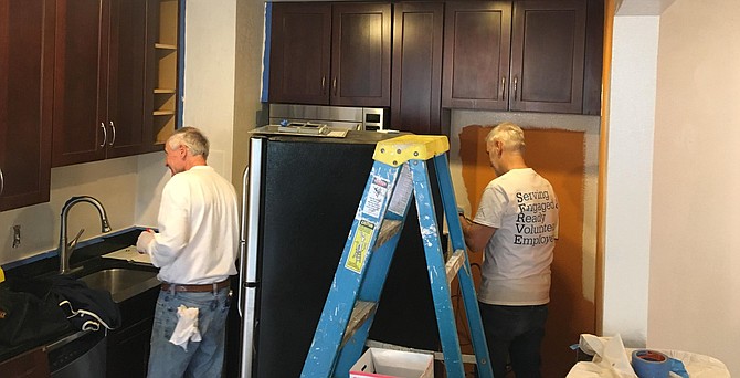 Volunteers for Rebuilding Together renovate a kitchen.