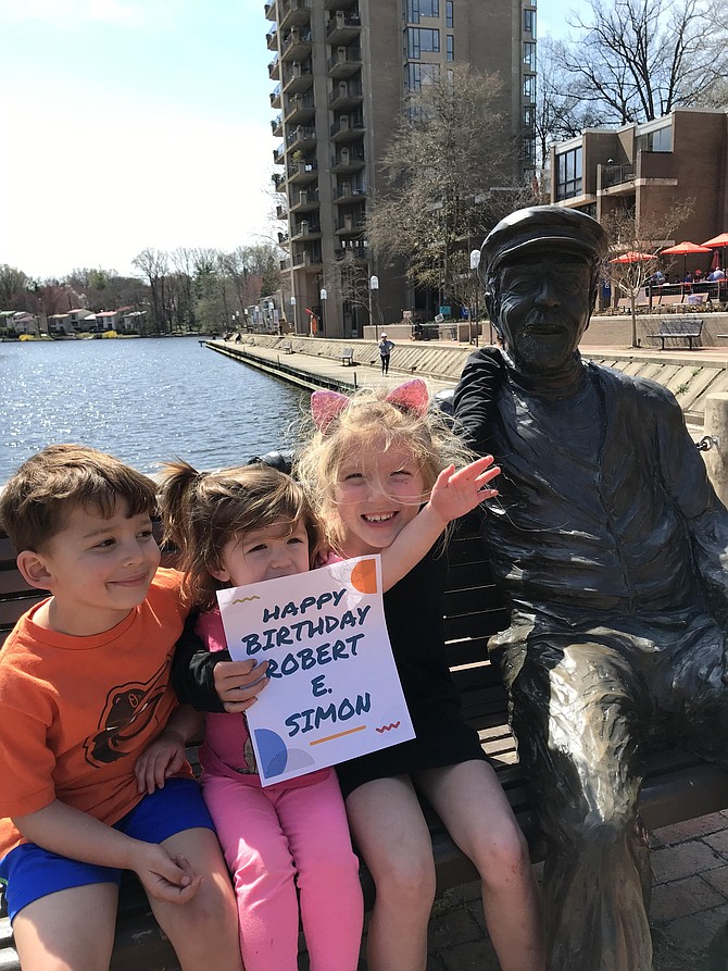 The Kooy children, Grant, 4, Eve, 2, and Ashton, 6, hold up a birthday wish sign for Reston's founder, Robert E. Simon, to celebrate 2019 Founder's Day. Melissa Romano, the owner of Lake Anne Brew House and Nordic Knot on the Plaza, made the birthday greeting sign for the special occasion.