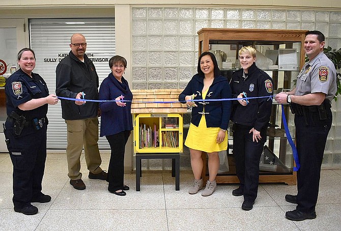 Cutting the ribbon for the Little Free Library are (from left) MPO Sherry O’Brien, retired MPO Denny Vorbau, Kathy Smith, Southita Brower, PFC Meg Hawkins and Lt. Todd Billeb.