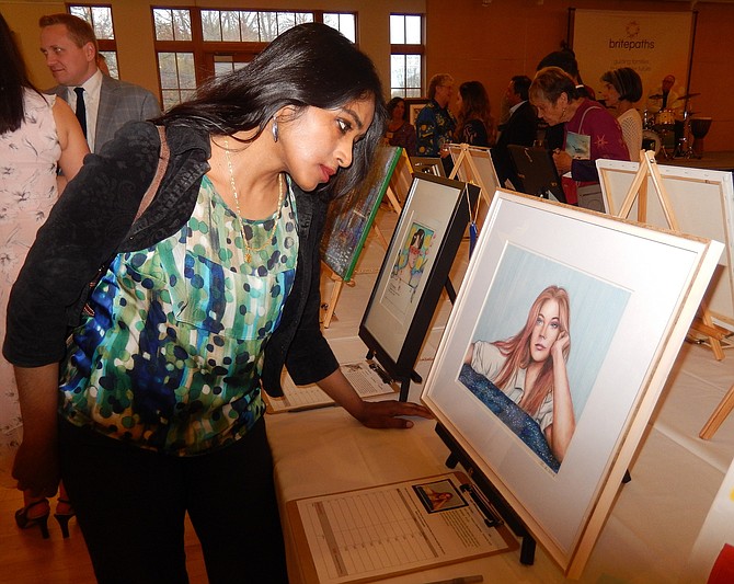 Shobha M. looks closely at a painting at last year’s “Artful Living.”
