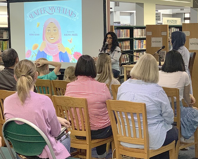 More than eighty children, teens and adults listen to remarks by children's author Hena Khan at the Reston Regional Library.