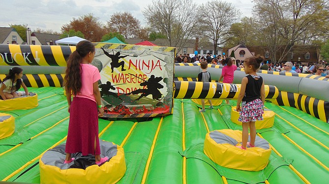 Children jump in the Ninja Warrior Inflatable ride.