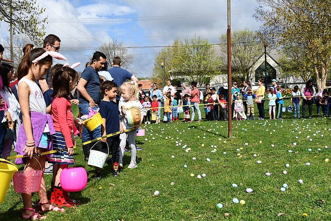Children press up against the caution tape lining the egg hunt area eagerly awaiting the start time.