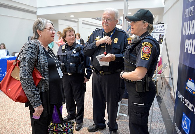 Auxiliary Police Officers, from left, Nina Aldrich, Fred Sanborn, and Ashley Soloff, were at the NoVa Positive Aging and Wellness Fair looking for recruits. Here they are working hard to convince Burke resident Dorothy Keenan to join their ranks. So – did they recruit Keenan? Probably not, since she is the “Champion” and leader of busy nonprofit “GrandInvolve.”