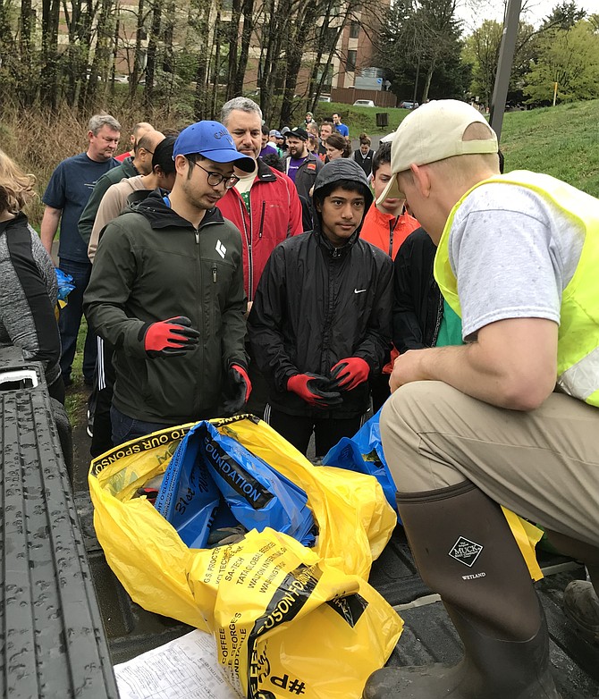 Garrett Stewart, watershed specialist with the Reston Association, distributes recycling and trash bags to volunteers during the 31st Annual Potomac River Watershed Cleanup coordinated by the Alice Ferguson Foundation and Reston Association.