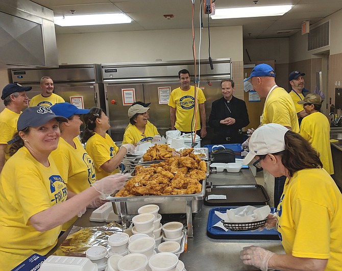 Bishop Michael Burbidge receives a tour of the kitchen operations and meets the volunteers.