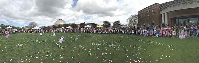 Hundreds of people circle the grassy Herndon Town Green behind the Municipal Center for the start of the 2019 Easter Egg Hunt.