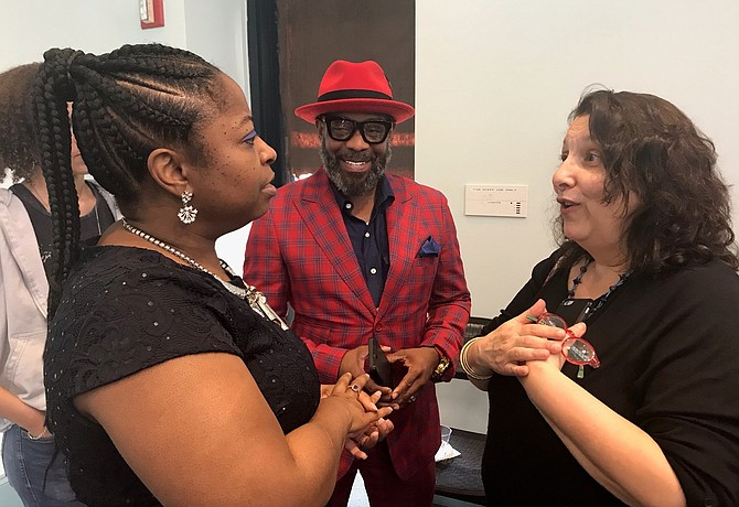 City of Alexandria Poet Laureate KaNikki Jakarta, left, speaks with Paul Young and outgoing Poet Laureate Wendi Kaplan at a reception April 12 at the Durant Arts Center.