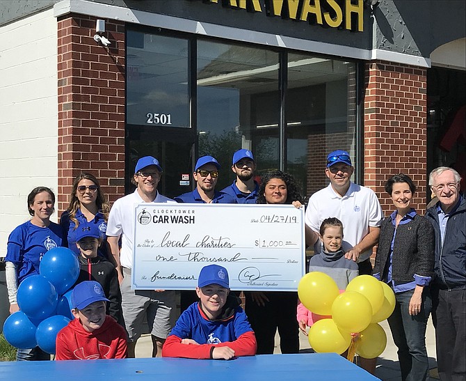 Clocktower Car Wash co-owners, Tim Ferraro and Gus Kearney, present a check for $1,000 to local charities during the business’s inaugural Spring Community Festival as (far right) State Senator Jennifer Boysko (D-33), Delegate Ken Plum (D-36) and others join in the fun.