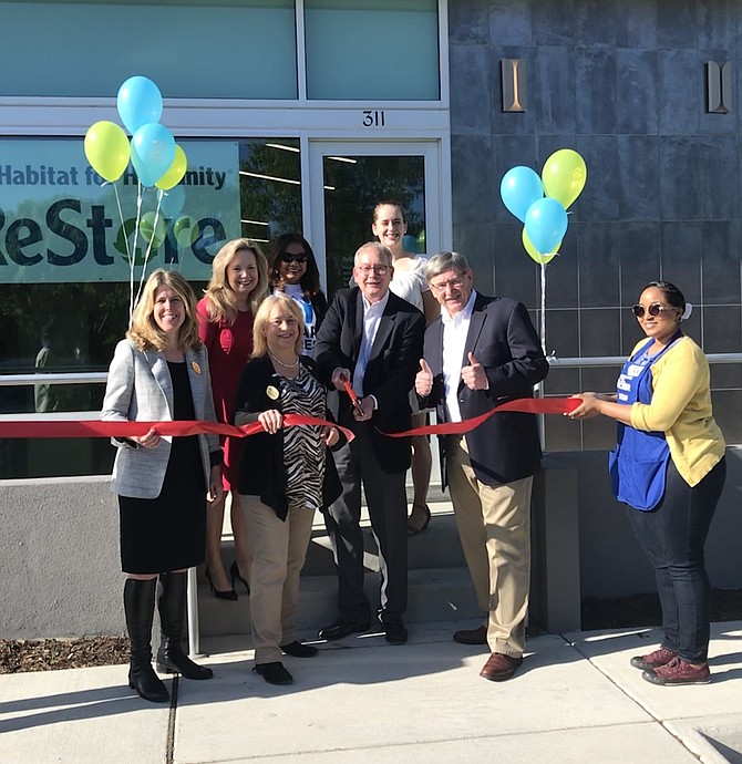 Jon Smoot, Executive Director of Habitat NOVA cuts the ribbon signifying the official opening of Herndon ReStore at 311 Spring Street, Herndon. With him, Herndon Councilmember Jennifer Baker, Vice Mayor Sheila Olem and Supervisor John Foust (D- Dranesville) and other supporters look on.