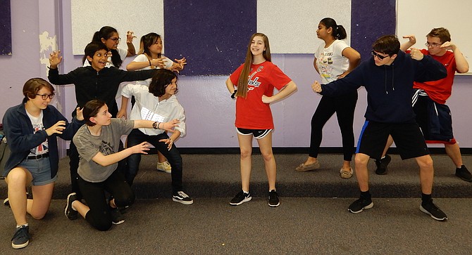 A spunky Red Riding Hood, Alyssa Dausch, is menaced by wolves on the left and protected by Power Mutants on the right.