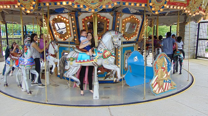 Visitors take a carousel ride at Clemyjontri Park in McLean.