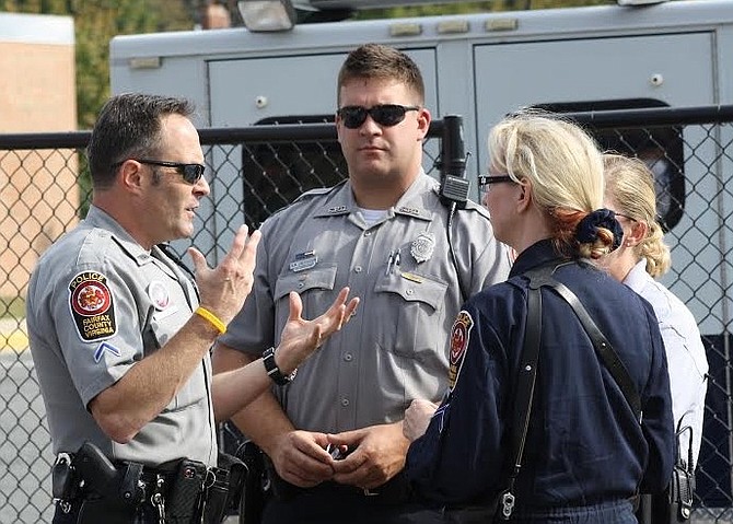 Ryan Lindenbaum (center) on the job, conferring with other police officers.