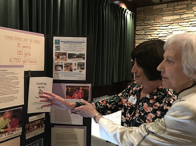 Leslie Tourigny, American Association of University Women (AAUW) of Virginia Co-President, and Dianne Mero, AAUW Reston-Herndon Area President, look over one of the historical displays presented at the organization's 50th Anniversary Celebration Luncheon.