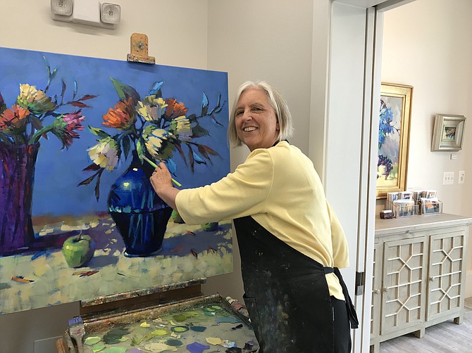 Trisha Adams paints in her newly opened art gallery/studio located at 708 Elden Street, Suite A.