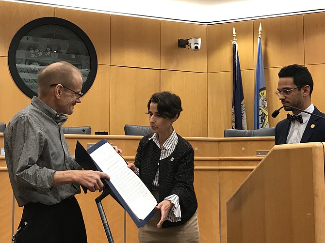 Son Mark Linek receives HJ 503 Celebrating the life of Chief Warrant Officer Edwin Linek, USN, Ret. memorial for his long-time community service, from State Sen. Jennifer Boysko (D-33) as Delegate Ibraheem Samirah (D-86) looks on.