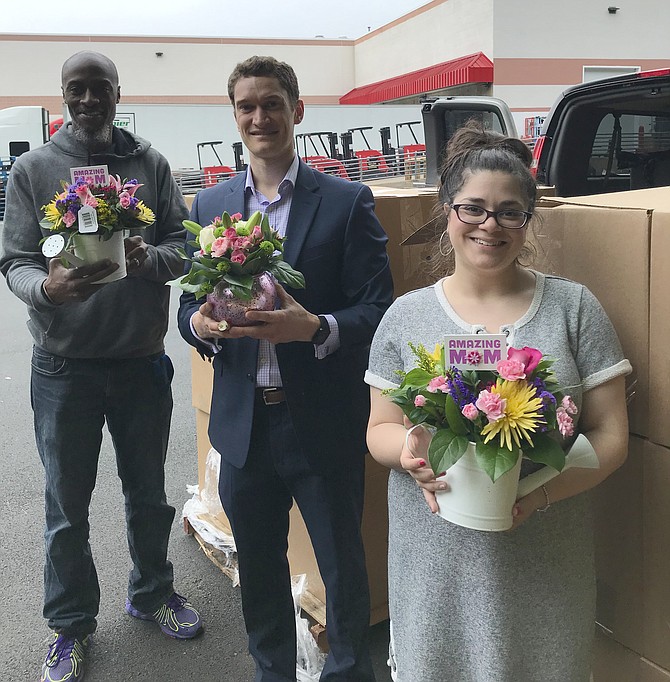From left:  Johnathan Johnson;  Kevin Barbera, Founder and CEO of the Barbera Foundation; and Terace Patti of  Shelter House, Inc. show off bouquets bought for mothers of domestic violence.