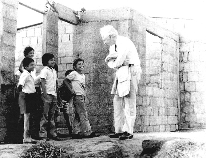 Peter Kimm on a housing site visiting with children.