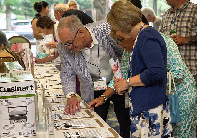 Attendees review auction items at the Culpepper Garden 2018 Springtime Party.