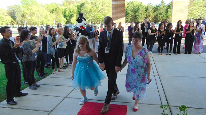 Andrew Valentine (center) escorts Gracie Craun and Andrea Cappello down the red carpet at the Joy Prom.