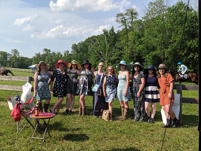 As the horses run by in the background, tailgaters at the Potomac Hunt Races enjoy the day. From left, Patty Sims, Suzannah Cornue, Megan Aprill, Natalie Hollis, Christine Raymer , Kathy Savory, Lara Schwartz, Cyndi Hill, Chelsea Eldridge, and Abigail Fulmer, from Destination Eventing and Miles Ahead Farm.