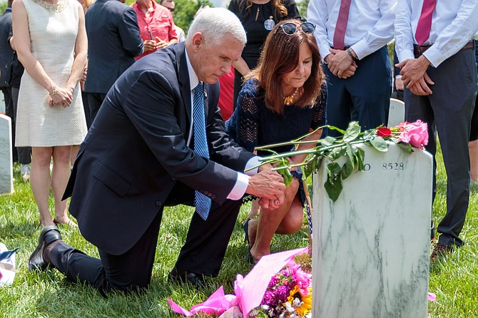 Vice President Mike Pence and his wife Karen lay flowers at the grave of Colonel Paul Kelly, who was killed in Iraq in 2007, in section 60 of Arlington National Cemetery on Memorial Day.