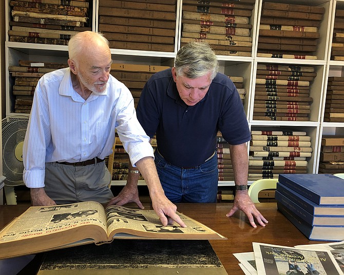 Freelance journalist Mike McMorrow, left, shows Col. Kevin Rue (ret.) information regarding the death of a Vietnam veteran found in the archives of the Alexandria Gazette last November. McMorrow was instrumental in locating photos of local Vietnam veterans as part of the national Faces of the Fallen project. He died May 18 at the age of 81.