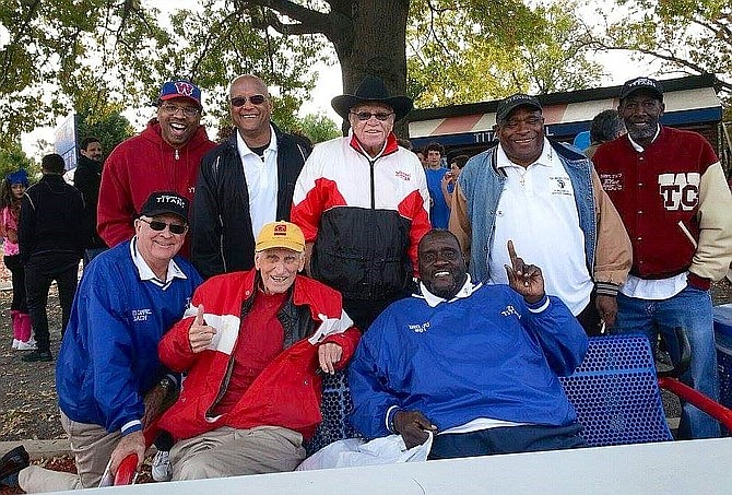 Coach Bill Yoast, seated at left, is shown with Coach Herman Boone, center back, and players from the 1971 TC Titans football team at the 50th anniversary of T.C. Williams High School in 2015.