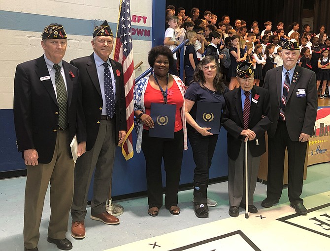 Lyles-Crouch Traditional Academy kindergarten teacher Wanda Allen and principal Dr. Patricia Zissios, center, stand with members of American Legion Post 24 after being honored for their efforts to promote patriotism at the school’s May 24 Memorial Day program. With Allen and Zissios are Henry Dorton, Post 24 Commander Doug Gurka, WWII veteran Col. Kim Ching and Jim Glassman.