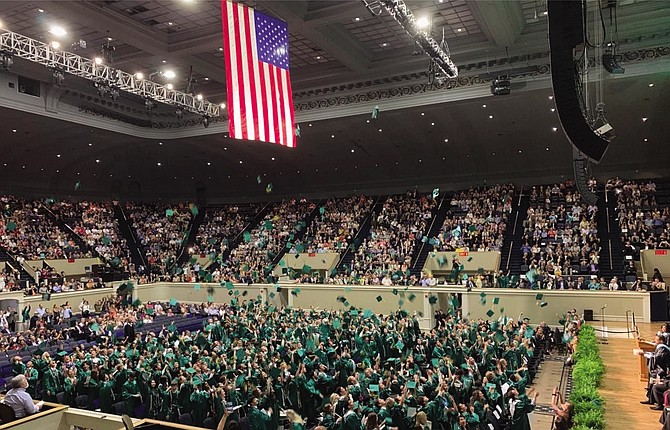 Students of Langley’s Class of 2019 toss their graduation caps into the air to celebrate their certification as official graduates.